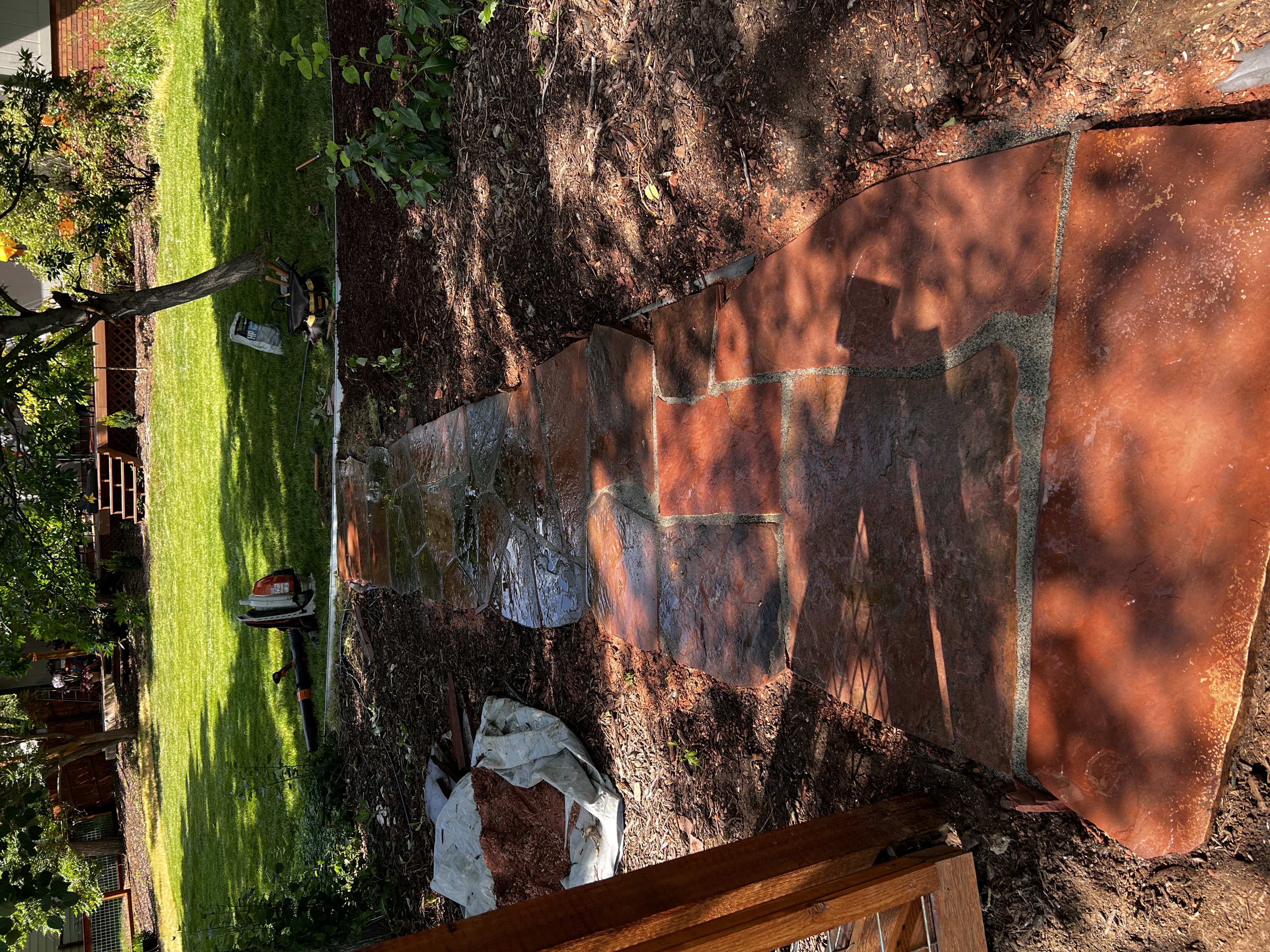 Patio stonework installation with fresh lawn